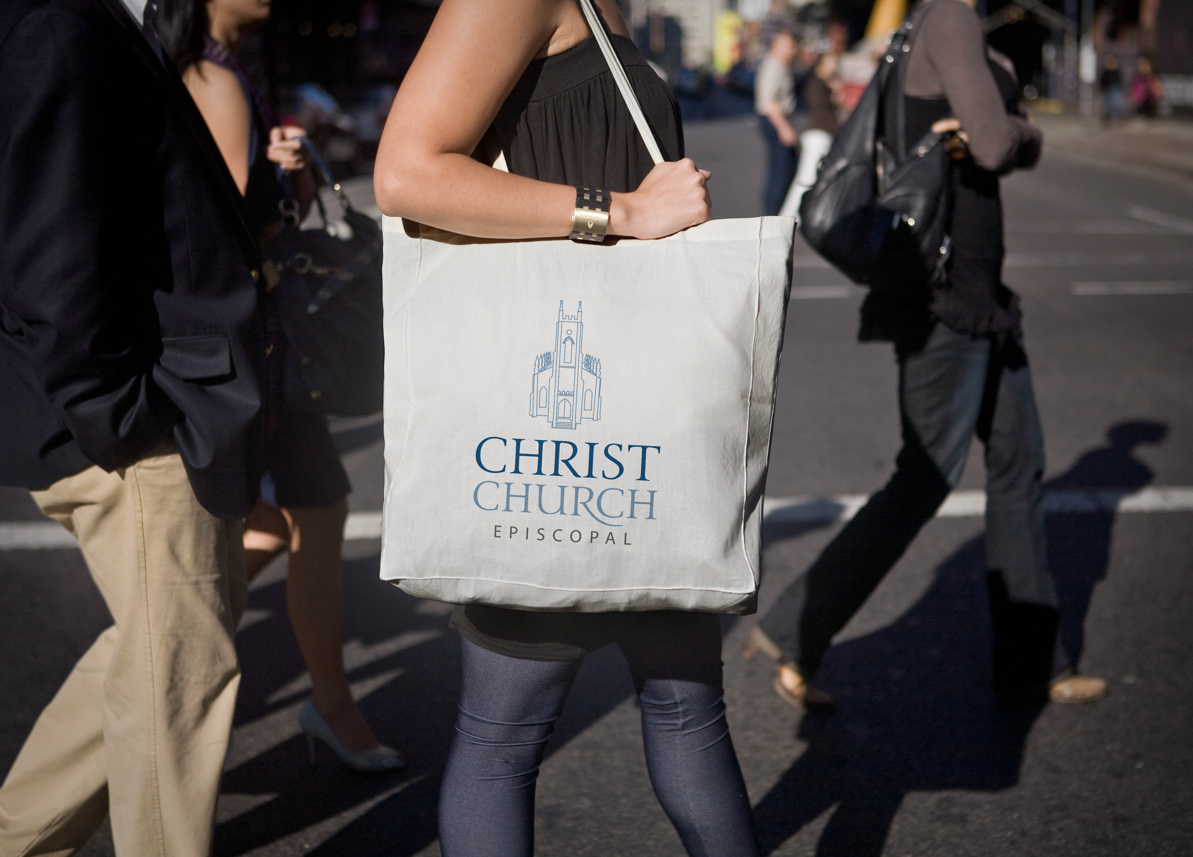 logo design for Christ Church Macon shown on a white tote bag held by a young woman