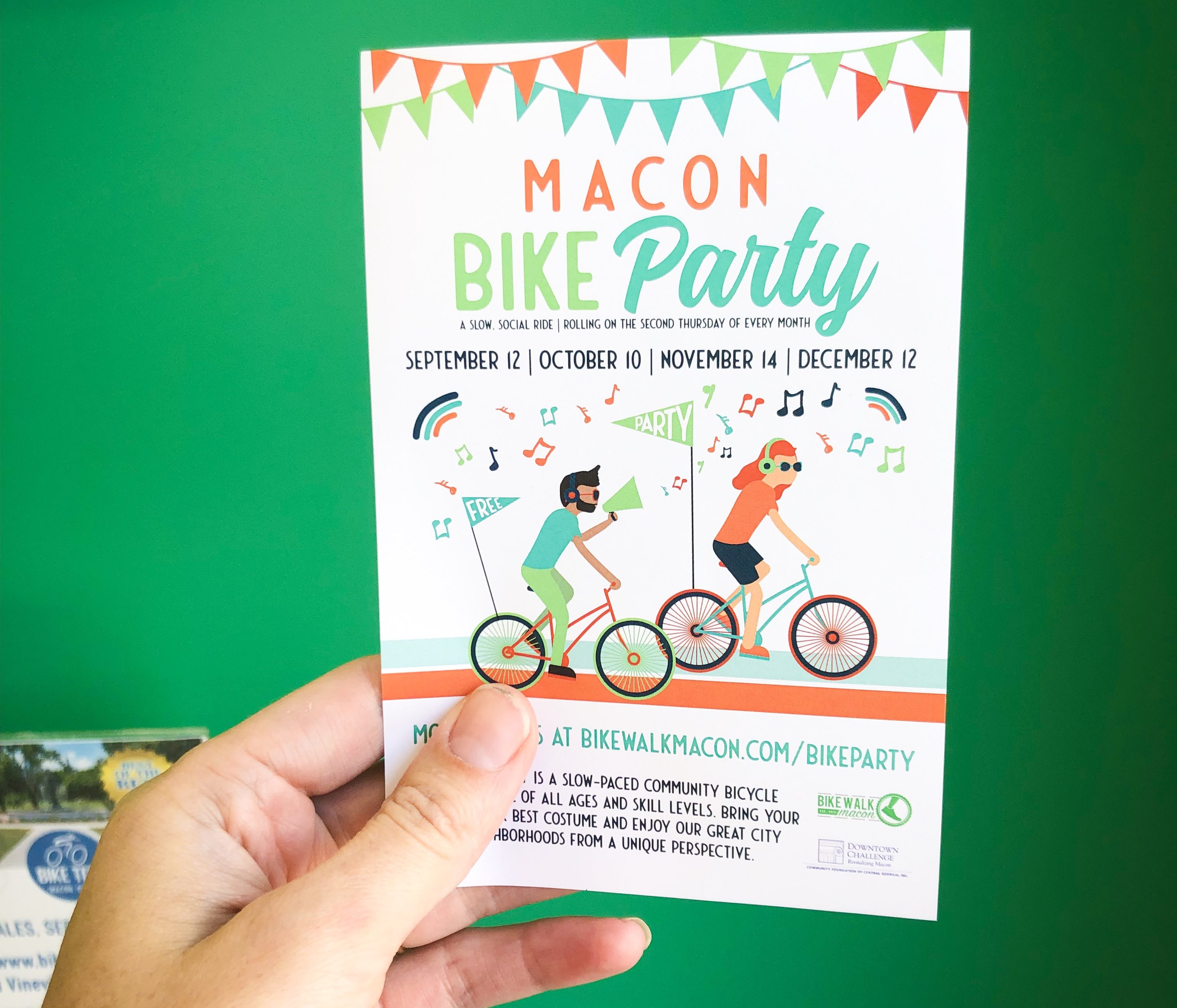 photo of hand holding a 'Macon Bike Party' flyer for Bike Walk Macon
